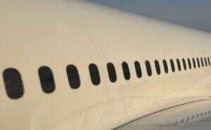 A parked Boeing 787 with a focus on the cabin windows.